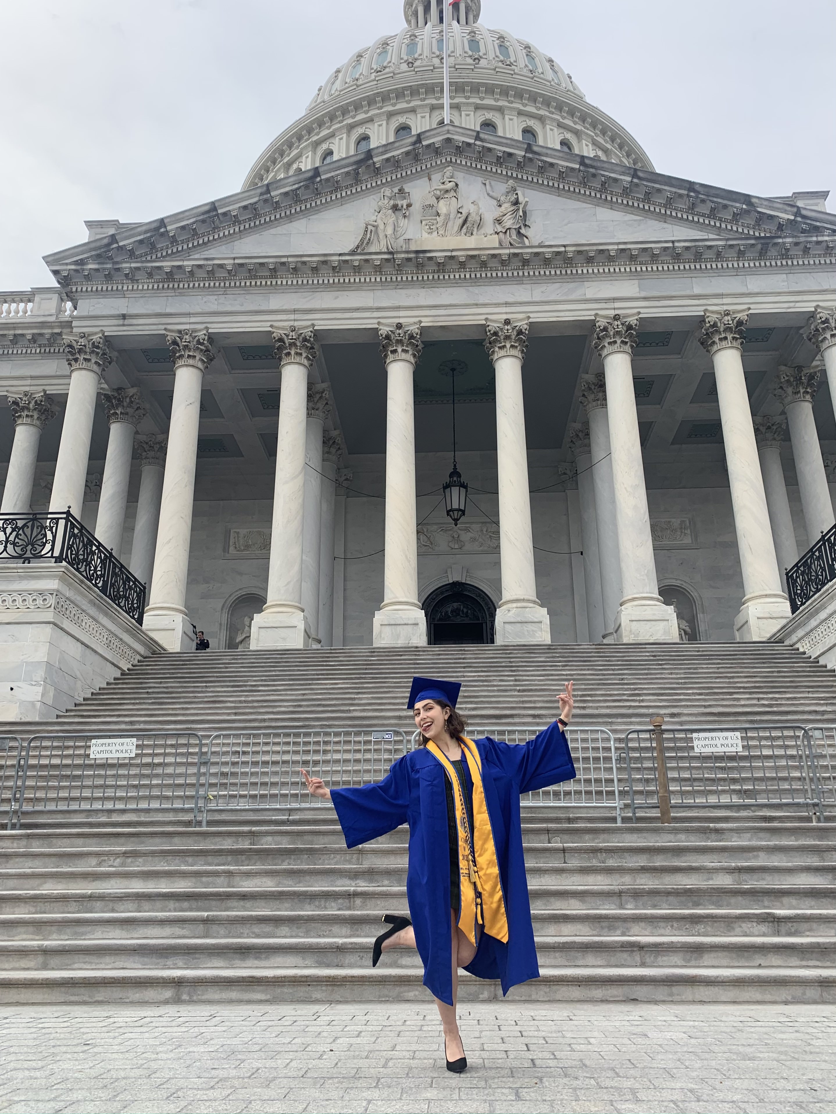 Photo of Liliana in a graduation cap and gown posing in front of the U.S. Supreme Court Building