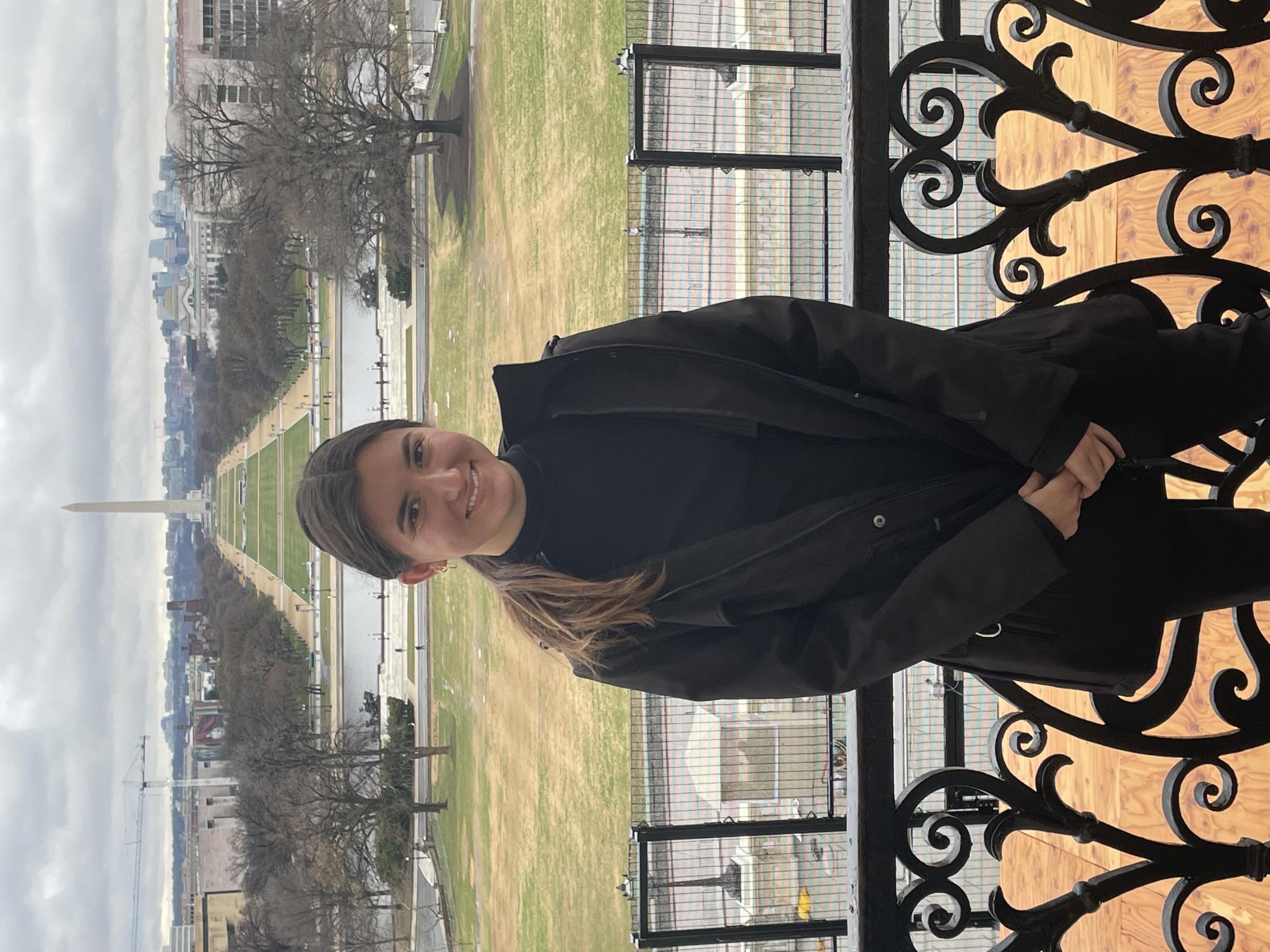 Louise Stivers standing in front of a railing. 