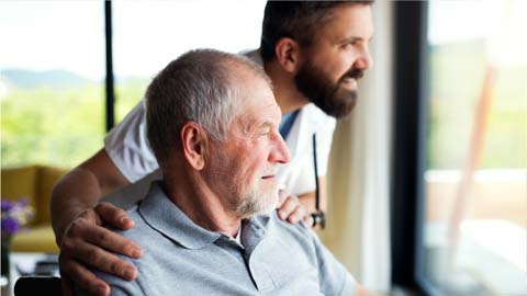 Elderly man looking out a window