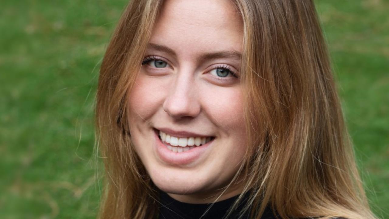 Headshot of Whitney Neumann behind a grassy area