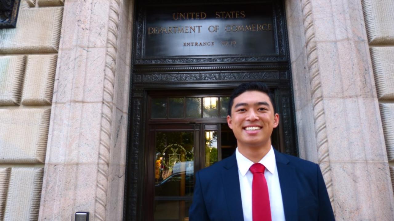 Student intern standing in front of the United States Department of Commerce building