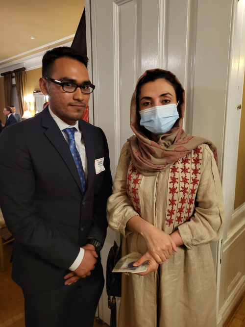 Christopher Rojas wearing a suit and standing next to an individual while in an embassy