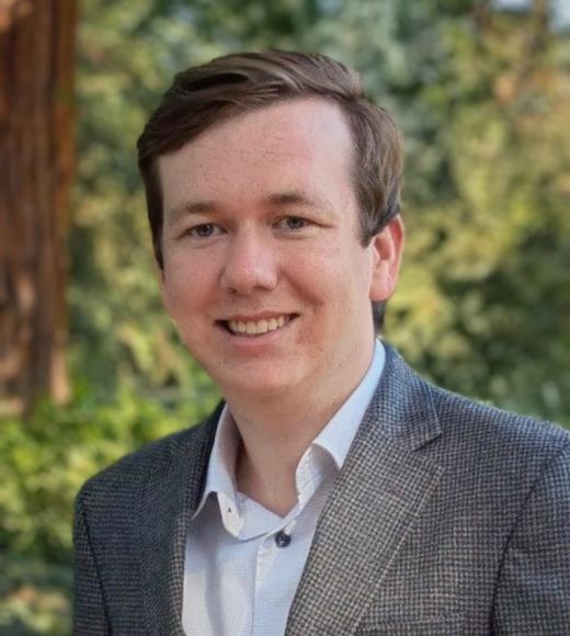 Image of Ethan in the foreground with greenery and a redwood tree background