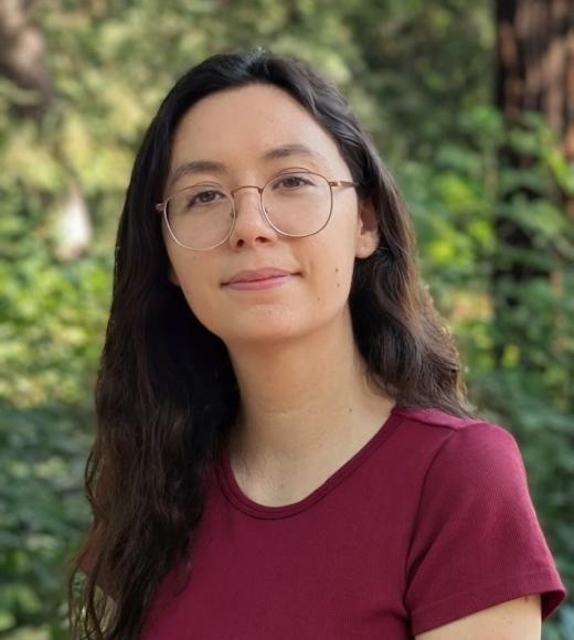 Image of Peer Advisor Natalie Crowley wearing red top and with a background of foliage and redwood trees.